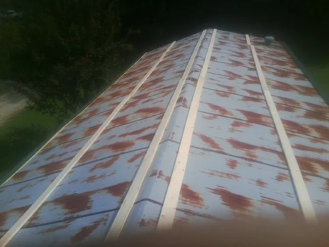 Rusted metal roof panels with new wood purlins before replacement — Storm Damage Roof Repair in Fruitland Park by Roofing Brothers